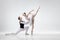 Young graceful couple of ballet dancers on white studio background