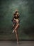 Young graceful tender ballerina on dark green studio background