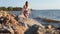 Young graceful woman walking barefoot on seaside