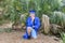 Young Graduate Proudly Posing In Front Of A Fan Palm With Cap And Gown