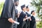 young graduated students in capes and hats holding