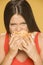 Young greedy woman eating a burger