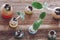 Young green seedlings in different eggs on wooden background. Top View. Easter concept, birth, spring