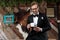 Young groom holding a cup and looking at his phone