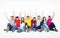 young group sitting together against white wall