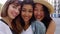 Young group of three diverse women smiling at camera standing together outdoors