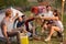 Young group toasting with bottles and glasses of beer in campground