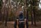 A young guy with a backpack in the hat, traveler, hipster standing in the woods, Hiking, Forest,Journey.Copy space