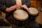 A young guy with a beard plays percussion bongos