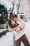 Young guy and beautiful girl kiss in a snowy park. Couple in sweaters.