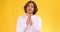 Young guy begging for something, holding hands in prayer gesture and pleading to camera, orange studio background