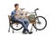 Young guy with a bicycle and a backpack sitting on a wooden benc