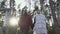 Young guy and the girl hold the hands and climb the wooden stairs and walk through the forest. Young couple spends time