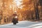 A young guy in a helmet is riding on a forest road on an electric motorcycle.