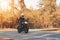 A young guy in a helmet is riding on a forest road on an electric motorcycle.