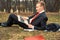 Young guy lying on the nature with a laptop. businessman working remotely outdoors. freelancer communicates over the