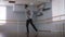 Young guy makes beautiful dance moves in a dance studio. Dancer wearing a gray sweater and black pants, rehearsing their