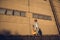 Young guy musician in a hat with a guitar against a wall of concrete