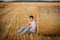 Young guy is relaxing in the countryside with a guitar. Plays the guitar . Resting lying on the hay