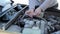 A young guy repairs a car