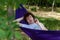 Young guy resting in a hammock in nature