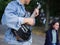 Young guy sings songs and plays guitar on a jeans jacket in a park on a natural background.