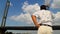 Young guy standing on yacht, sailing underneath the city bridge