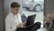 Young guy in suit is using laptop sitting on window sill