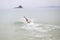 The young guy swimming in the ocean. On the background mountain on the island and the banks Peninsula
