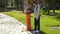 Young guy taking off receiver of payphone, standing and holding phone at ear