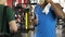 Young guy talking to friend in gym, drinking protein cocktail, showing biceps