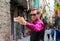 A young guy, a tourist does selfie on a mobile phone in the street Girona, decorated with colorful shawls