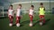 Young guys schoolchildren put balls on soccer field