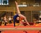 Young gymnast girl performing routine on balance beam