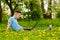 Young gyu freelincer at work on a laptop on a green grass and trees background