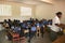 Young Haitian school girls and boys with teacher in classroom.