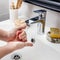 Young hands frothing with soap with beauty accessories on sink