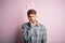 Young handsome adult man wearing cute easter rabbit ears over pink isolated background thinking looking tired and bored with