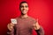 Young handsome african american man holding reminder paper with yes message happy with big smile doing ok sign, thumb up with