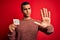 Young handsome african american man holding reminder paper with yes message with open hand doing stop sign with serious and