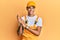 Young handsome african american man wearing handyman uniform over yellow background clapping and applauding happy and joyful,