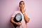 Young handsome african american slim sportsman using weight machine over pink background cover mouth with hand shocked with shame