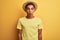 Young handsome arab man wearing t-shirt and summer hat over isolated yelllow background afraid and shocked with surprise
