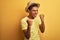 Young handsome arab man wearing t-shirt and summer hat over isolated yelllow background very happy and excited doing winner