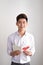 Young handsome asian man reads greeting card with heart shape on white background