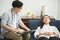 Young handsome asian psychologist doctor using laptop consulting to female patients lay down on sofa in therapy session