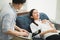 Young handsome asian psychologist doctor using laptop consulting to female patients lay down on sofa in therapy session