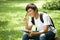 Young handsome Asian student with books and smile in outdoor