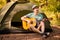 Young handsome attractive bearded model man in hat playing guitar in forest.