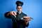 Young handsome baker man wearing cooker uniform and hat holding tray with cake with angry face, negative sign showing dislike with